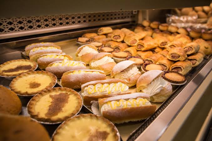 Warm Oven baker preparing a fresh bakery selection